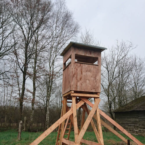 Offene Jagdkanzel Waidmann aus Holz in einem bewaldeten Gebiet mit kahlen Bäumen