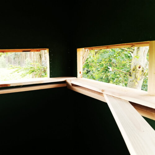 Innenansicht der Schlafkanzel Brandfuchs mit Blick auf die Natur durch Fenster