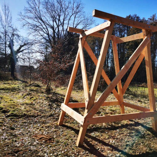 Holzunterbau für Jagdkanzeln mit Leiter und Handlauf im Wald bei Sonnenschein