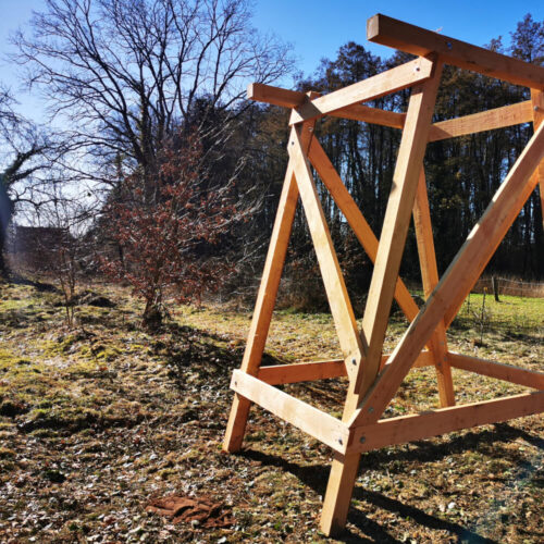 Holzunterbau für Jagdkanzel mit Leiter und Handlauf im Wald bei sonnigem Wetter