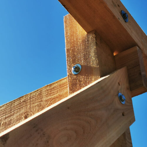 Holzstruktur des Unterbaus für Jagdkanzeln mit Schrauben und blauen Himmel